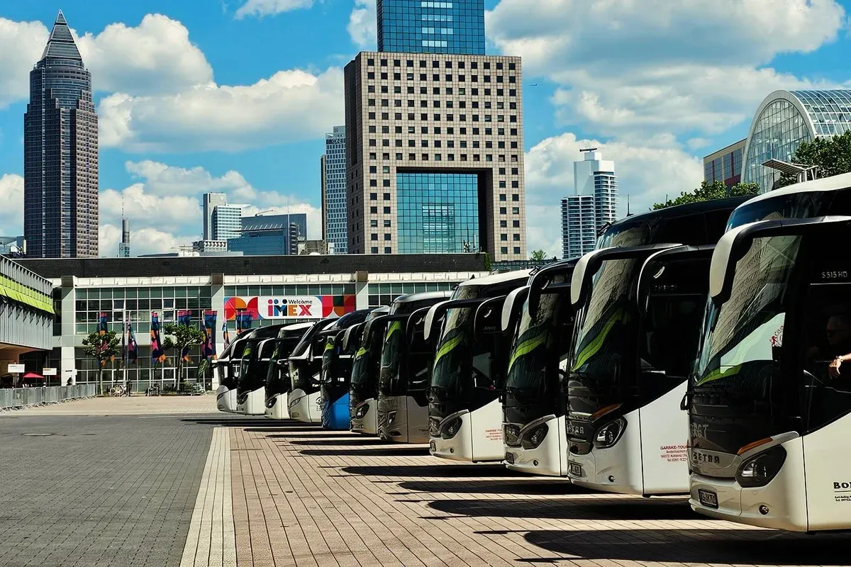 Reisebus-Reihe vor der Frankfurter Skyline bei der IMEX